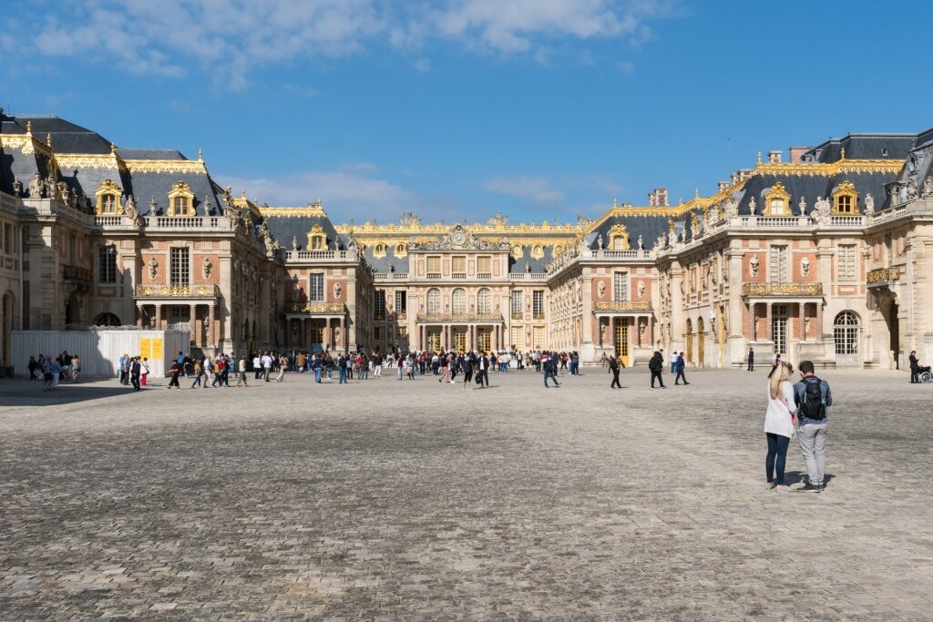 People exploring the Palace of Versailles, Paris