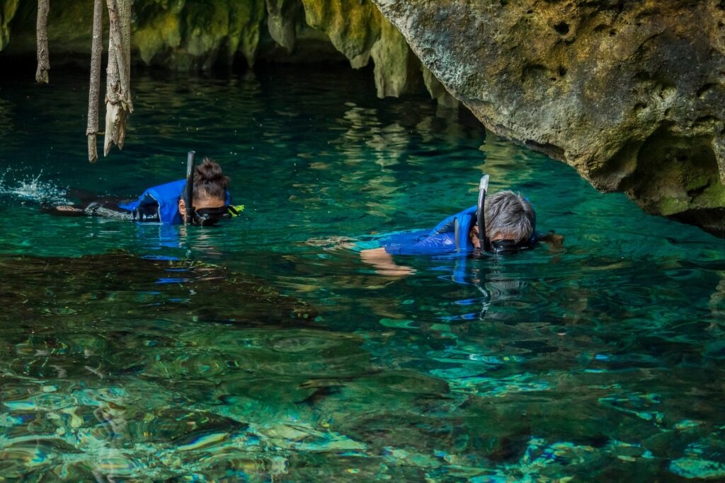 People snorkeling in a cenote in Tulum