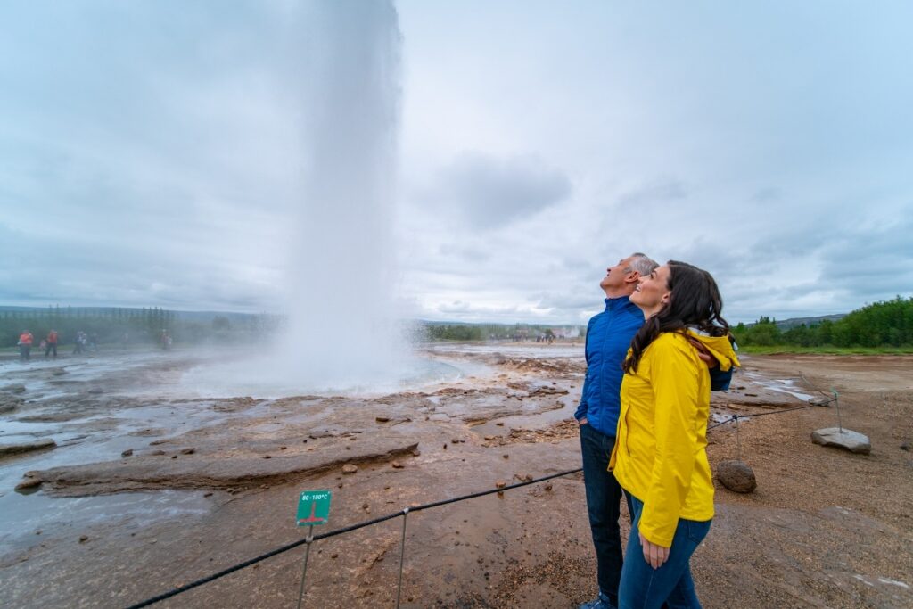 Couple looking at a geysir in Iceland