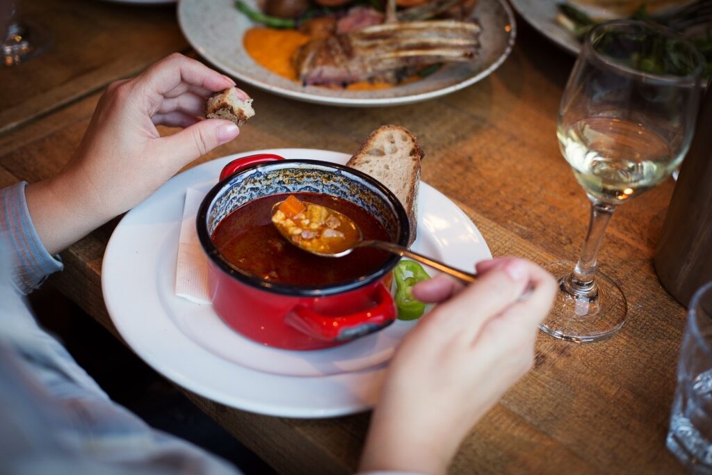 Person eating Hungarian goulash inside Café Hadik