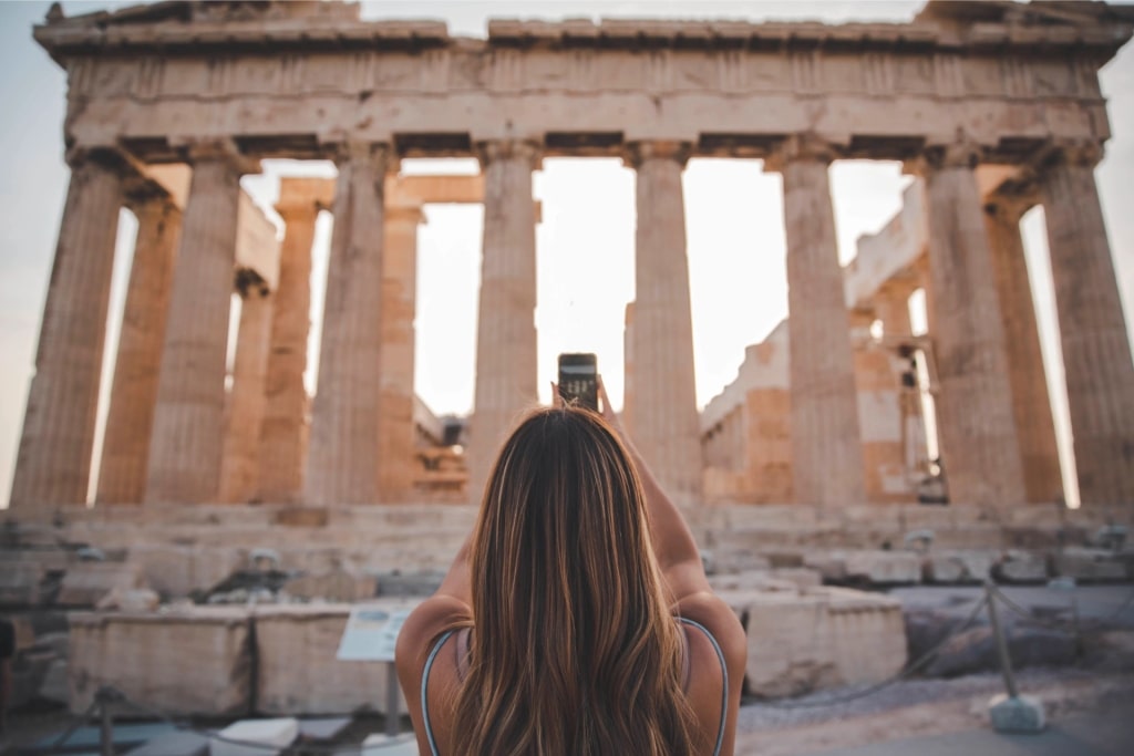 Woman taking a photo of Parthenon in Athens, Greece