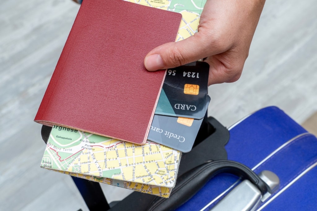 Person holding passport and credit cards
