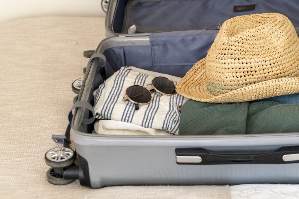 Suitcase with hat, sunglasses and shirts