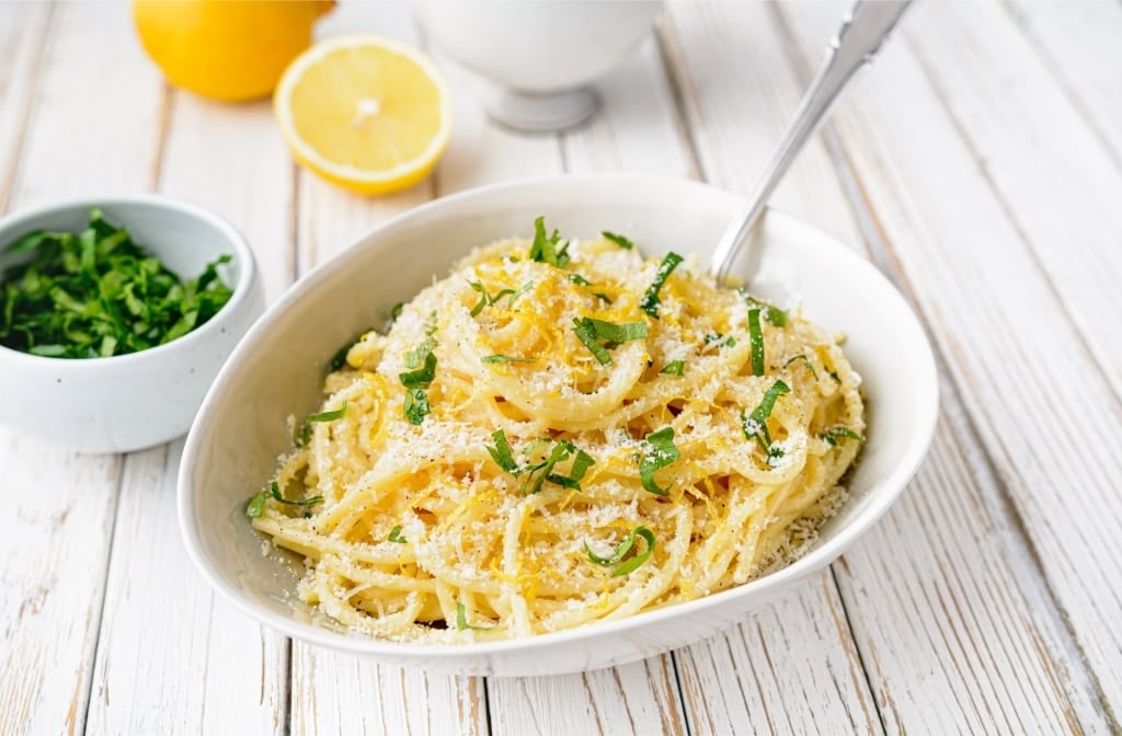 Pasta al limone in a bowl with fresh lemon