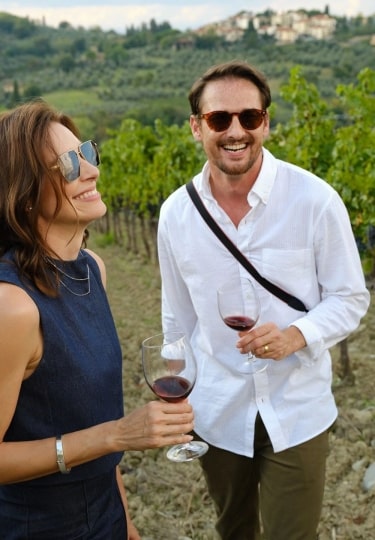 Couple enjoying a glass of wine at a vineyard in Tuscany, Italy