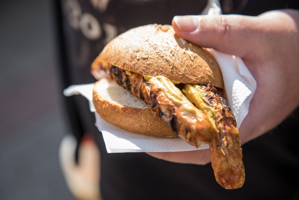 Man holding sausage sandwich