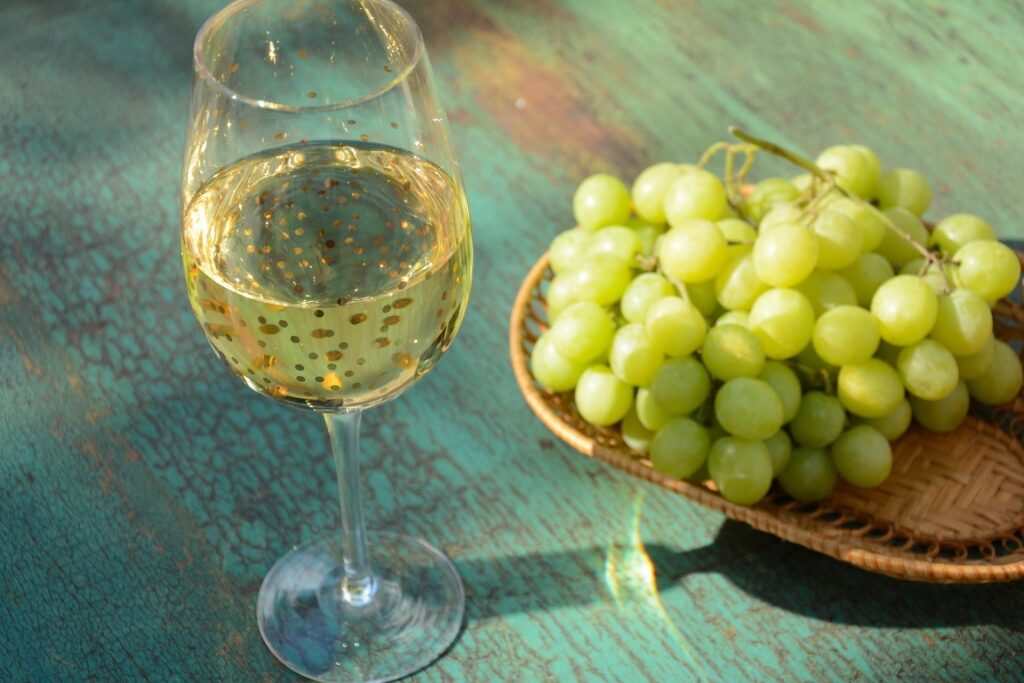 White wine in a glass with grapes