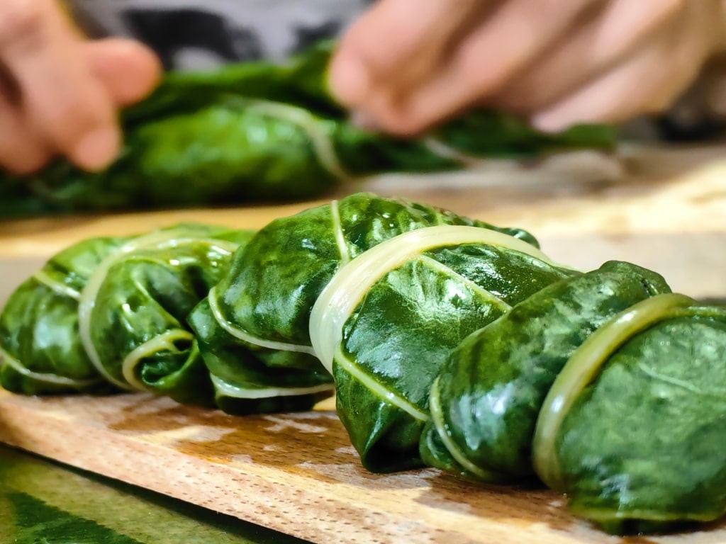 Person wrapping Swiss chard