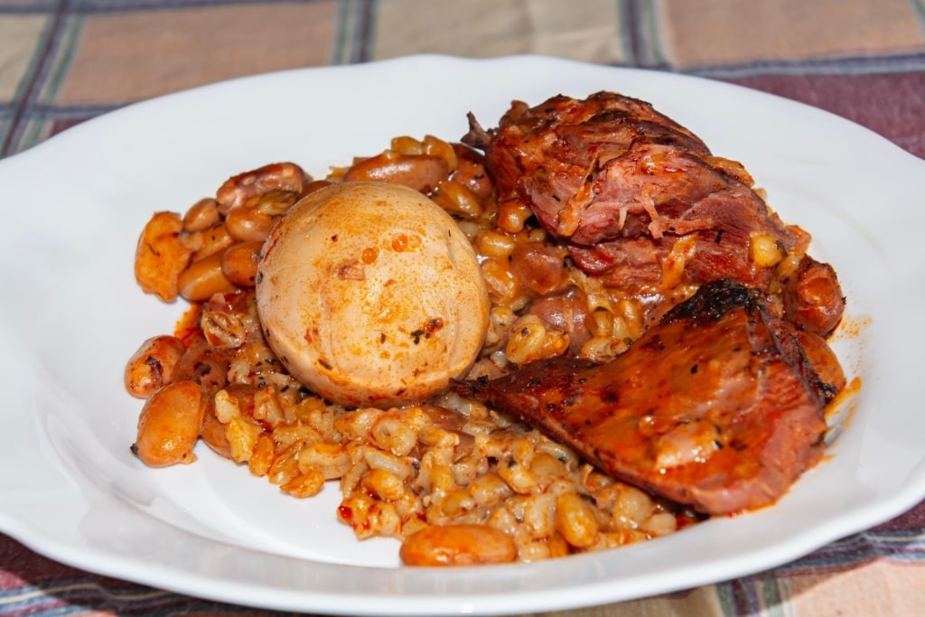 Sólet served with smoked meat, beans, and boiled egg