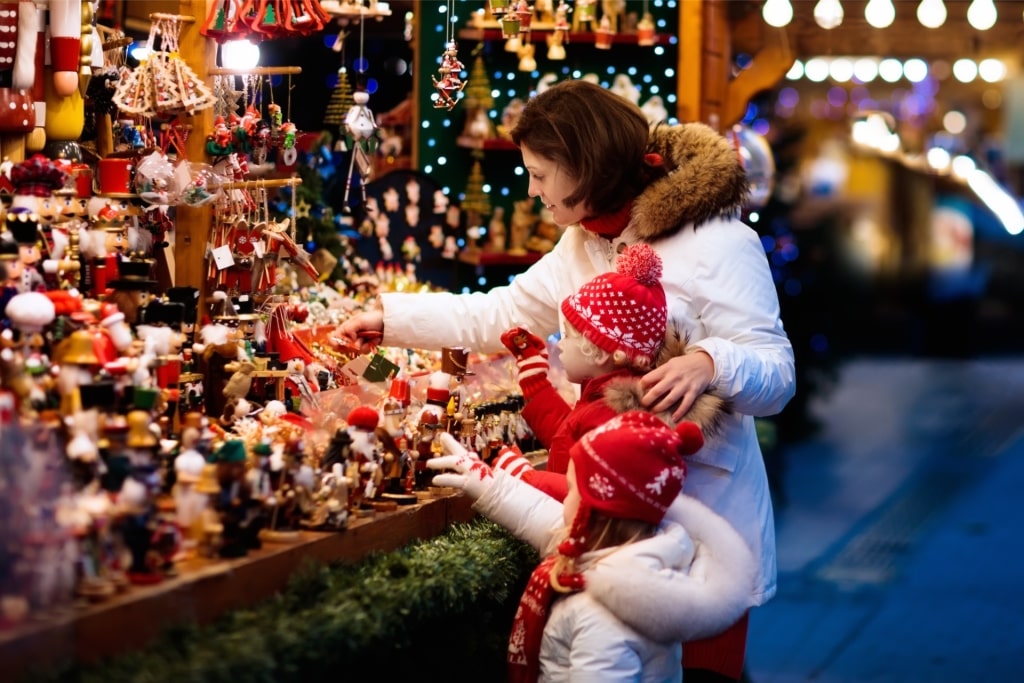 Christmas market in Germany with shoppers in winter clothing