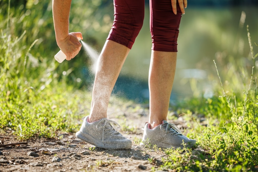 Woman applying insect repellent