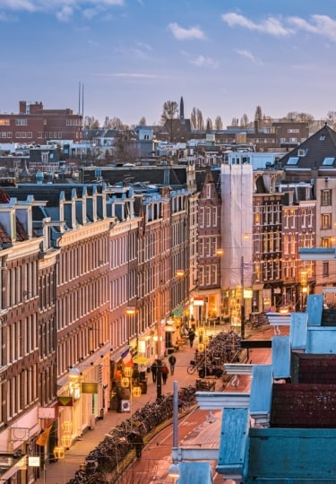 Amsterdam’s De Pijp neighborhood with lit street