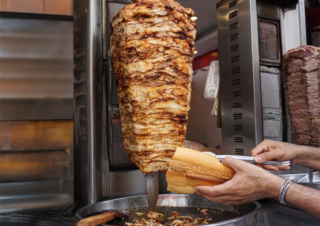 Authentic Turkish döner kebab being sliced and served in bread