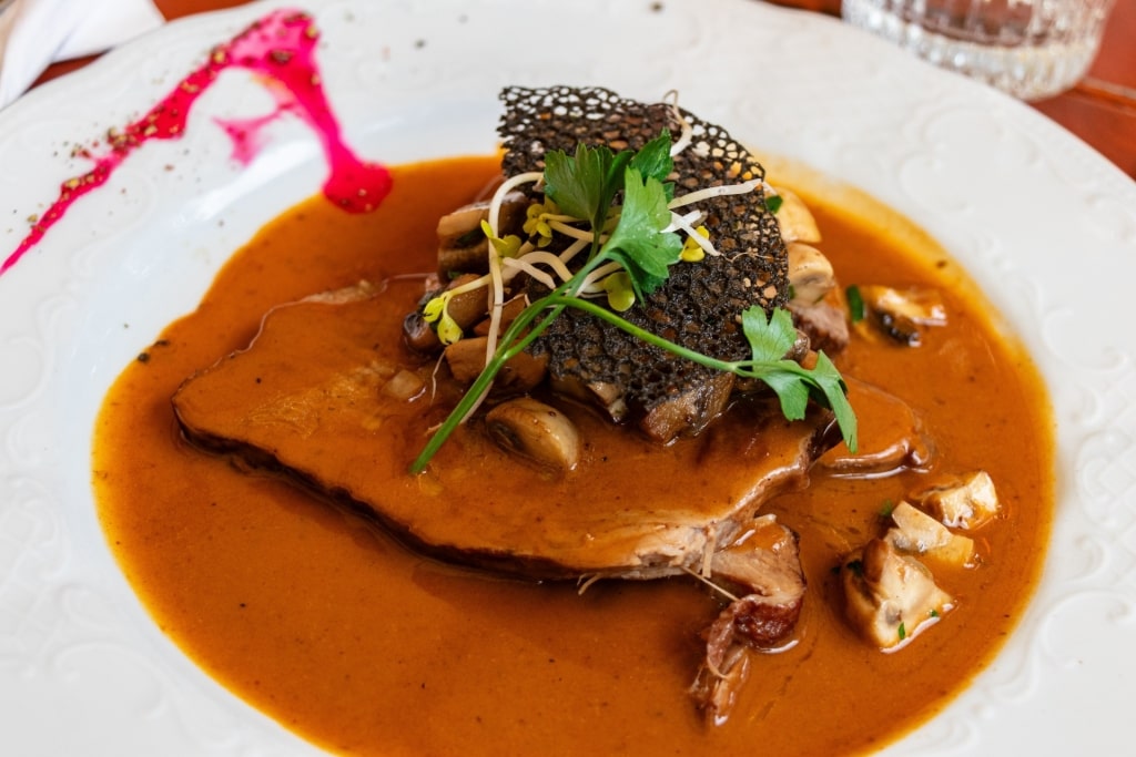 Traditional German Sauerbraten served with rich mushroom sauce and vegetables