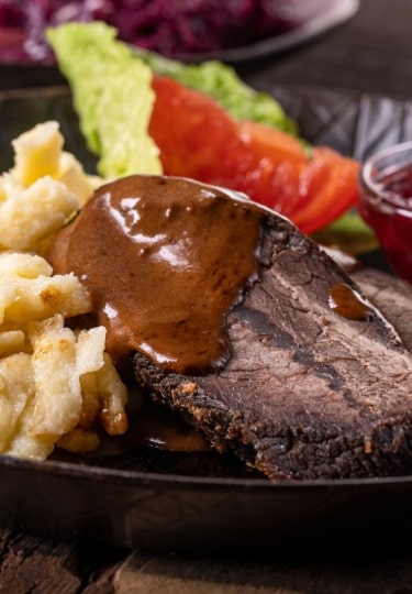Plate of Sauerbraten, marinated beef roast with gravy, specialty food in Cologne