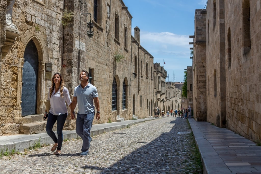 Couple exploring the cobbled streets of Old Town of Rhodes, Greece