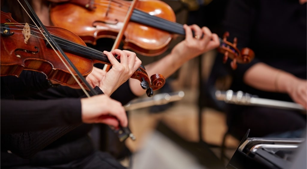 Close up of musician’s hands playing violin