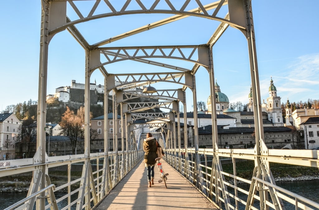 Tourist walking across metal bridge in Salzburg