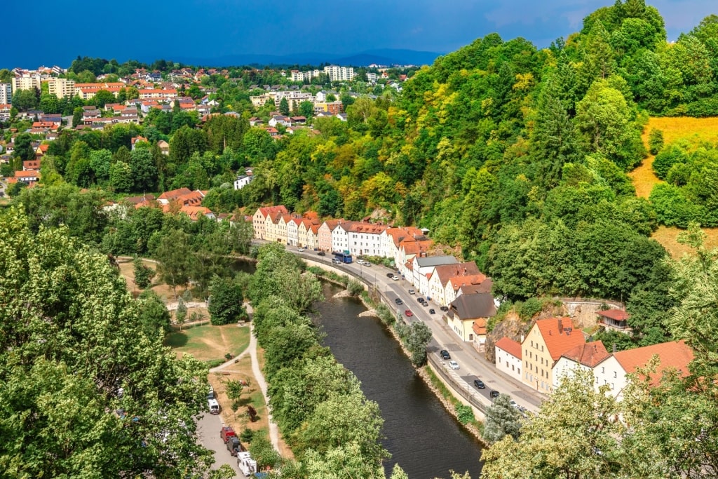 Historic houses and buildings among greenery along the river in Passau