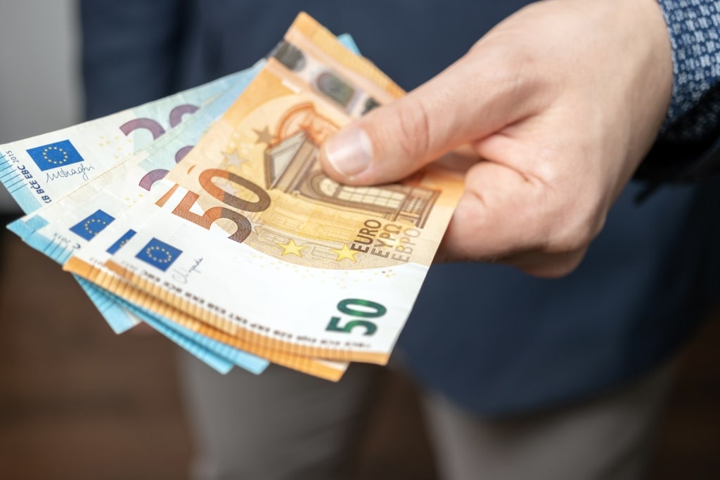 Man holding euro banknotes in hand as cash payment