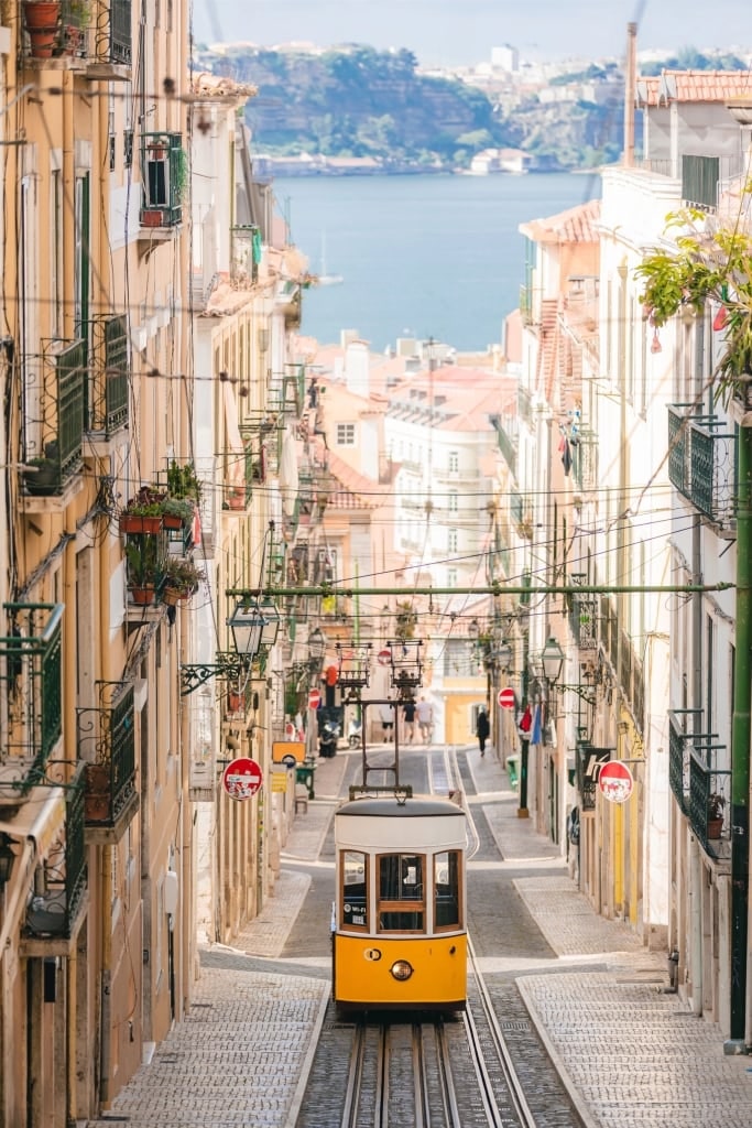 Scenic view of Lisbon with iconic yellow tram passing through historic street