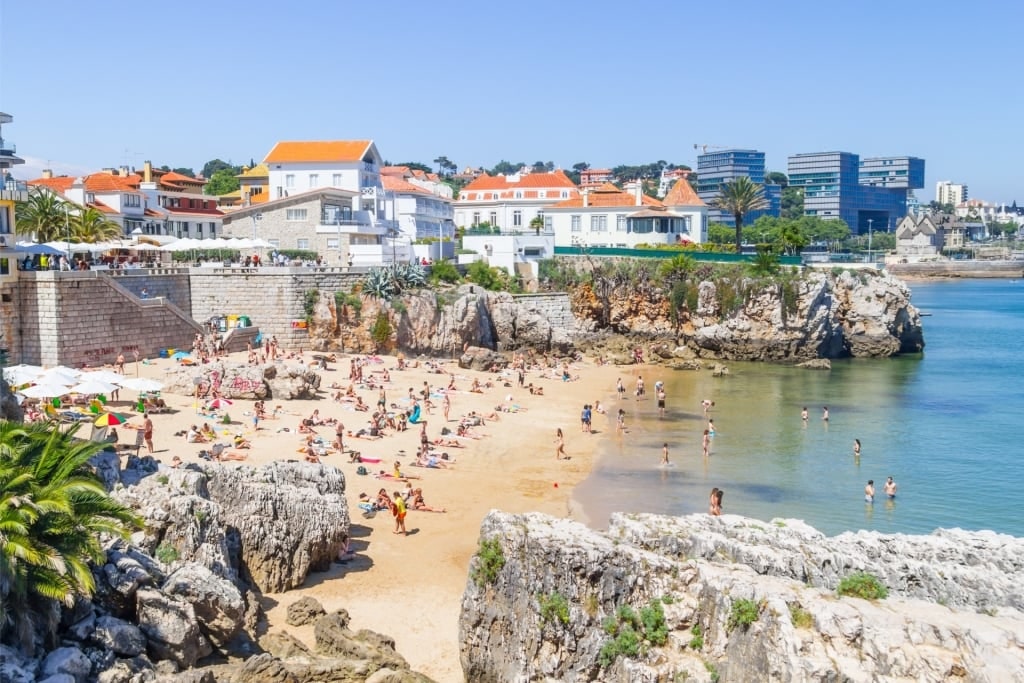 Crowded beach in Cascais with sunbathers and swimmers in Portugal