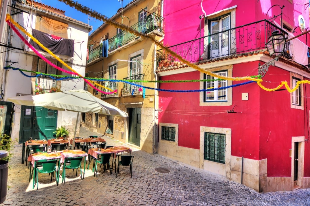 Charming Lisbon street with outdoor dining tables and umbrella