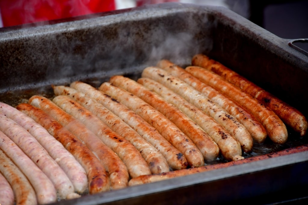 Authentic German bratwurst on barbecue grill at outdoor market
