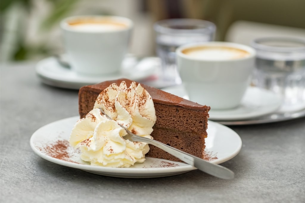 Slice of decadent sacher torte with coffee
