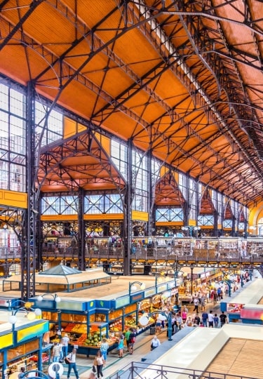 Interior of Central Market Hall with stalls and people shopping in Budapest