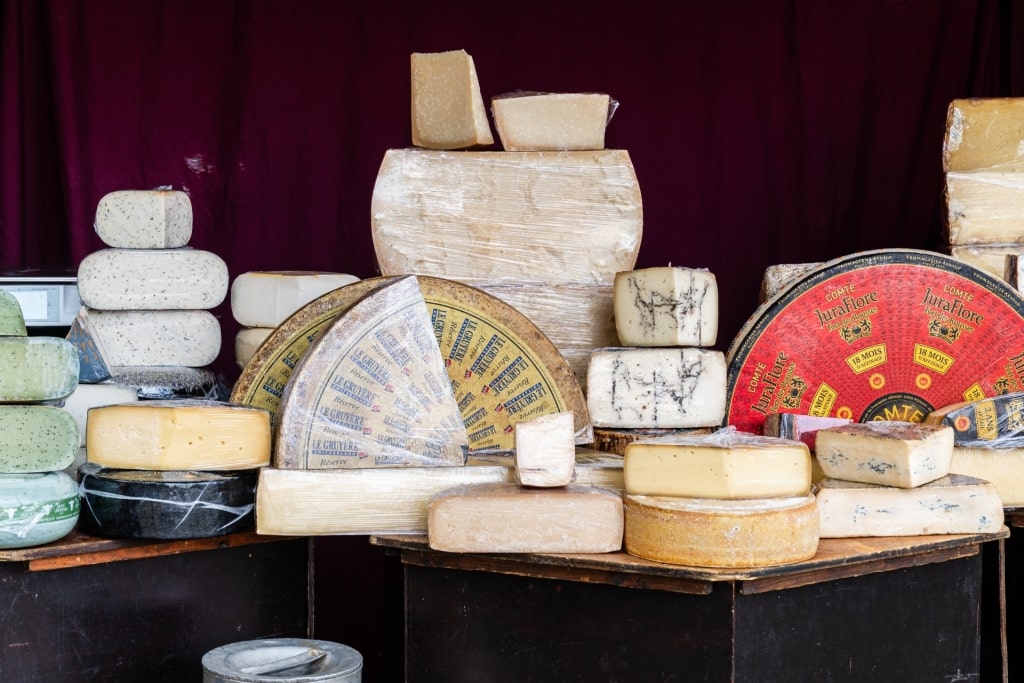 Artisanal cheese wheels, wedges, and blocks on display at Barcelona market stall