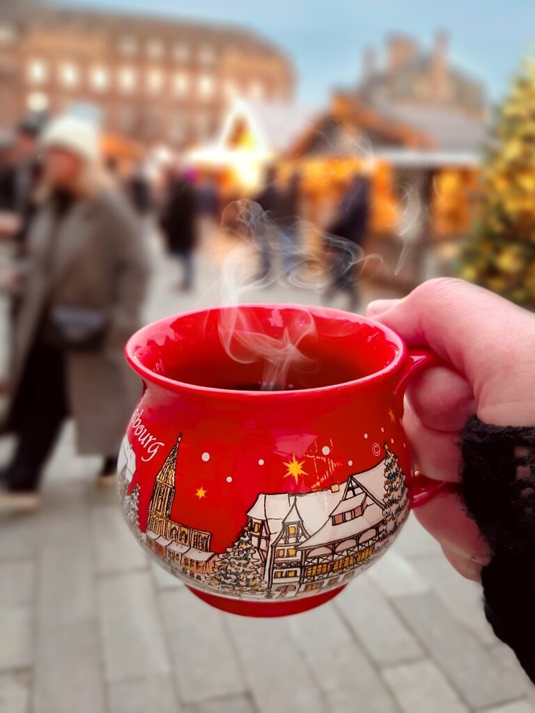 Person holding a cup of glühwein mulled wine