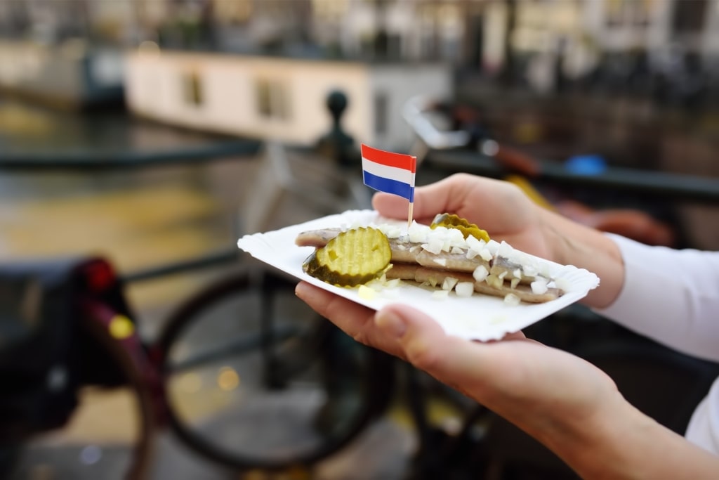 Popular Amsterdam street food haring eaten with pickles and onions