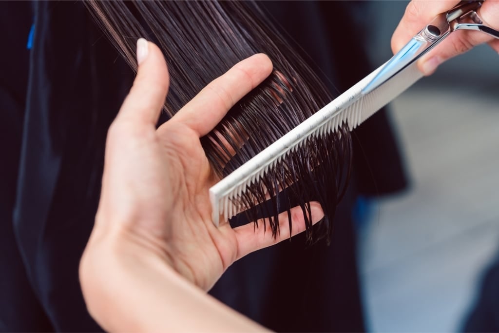 Stylist trimming hair at a salon