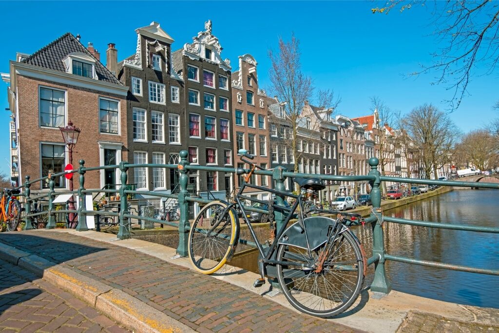 Bicycle parked along Reguliersgracht canal with scenic Amsterdam backdrop