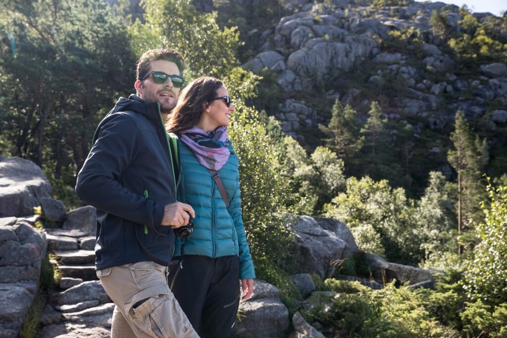 Couple enjoying scenic view from Pulpit Rock above Lysefjord, Norway