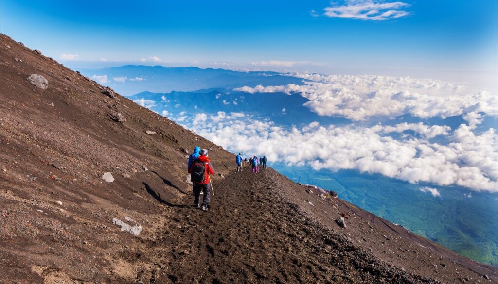 View from Mount Fuji summit with hikers overlooking clouds