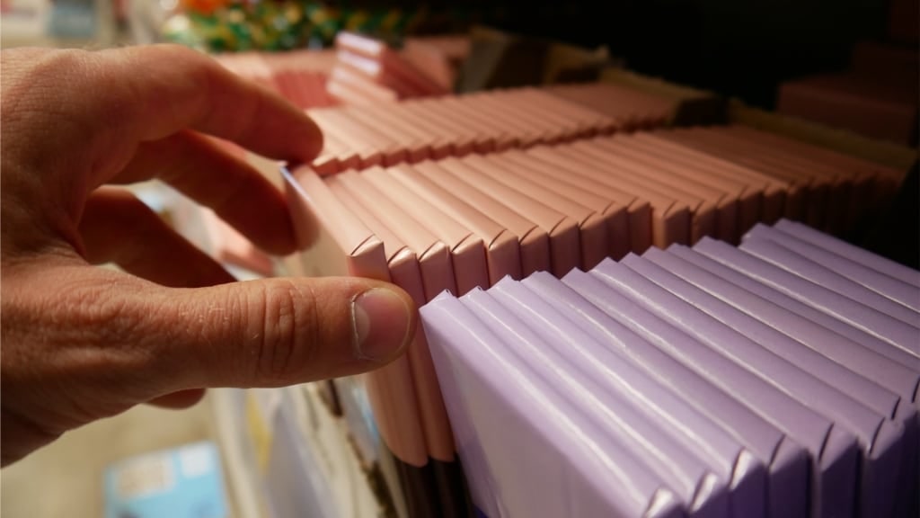 lose-up of a customer’s hand picking up a chocolate bar from a retail display