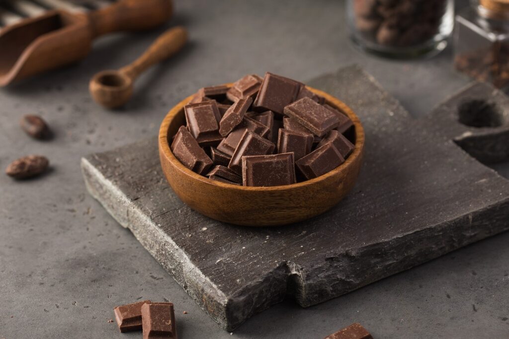Milk chocolate pieces in a wooden bowl