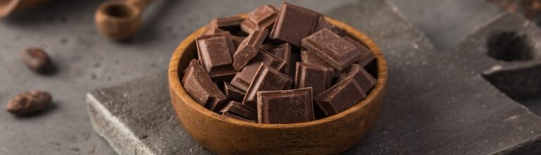Milk chocolate pieces in a wooden bowl