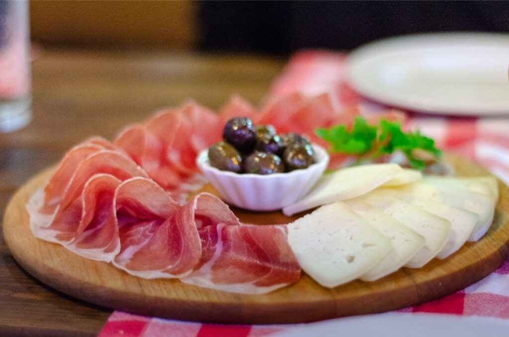 Njeguški pršut with traditional Montenegrin cheese on a rustic wooden plate