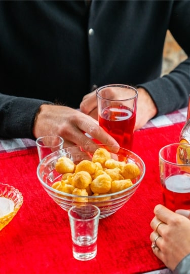 Traditional Montenegrin priganice fried dough balls with drinks