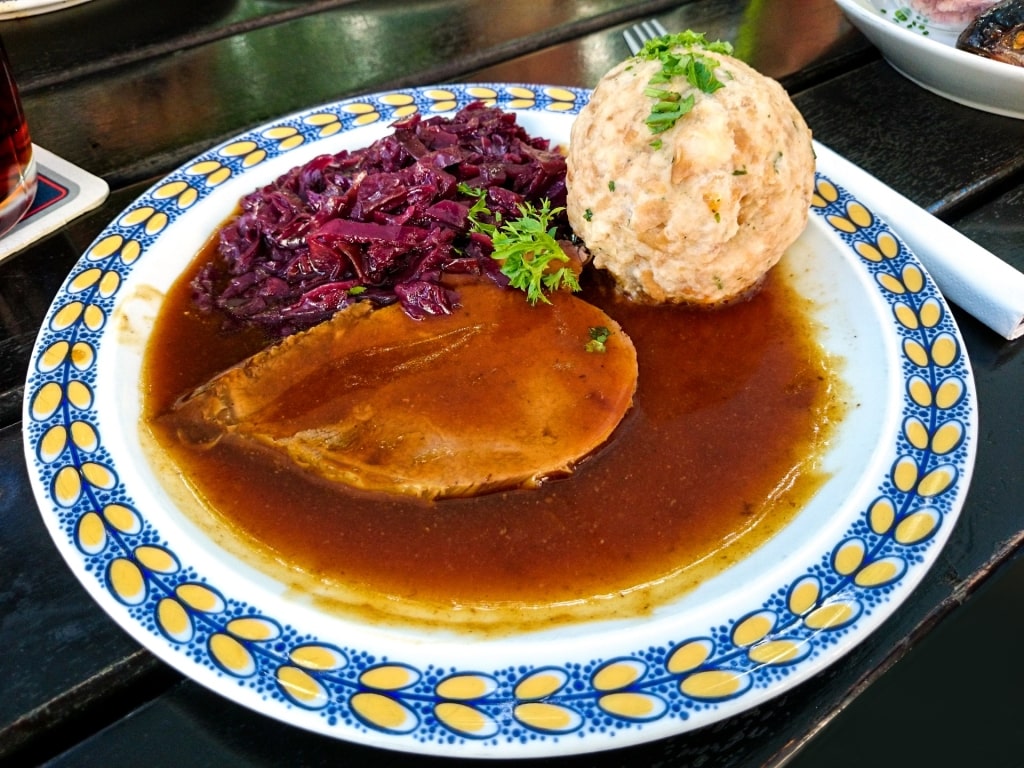 Authentic Sauerbraten dish with red cabbage, potato dumpling, and rich brown sauce