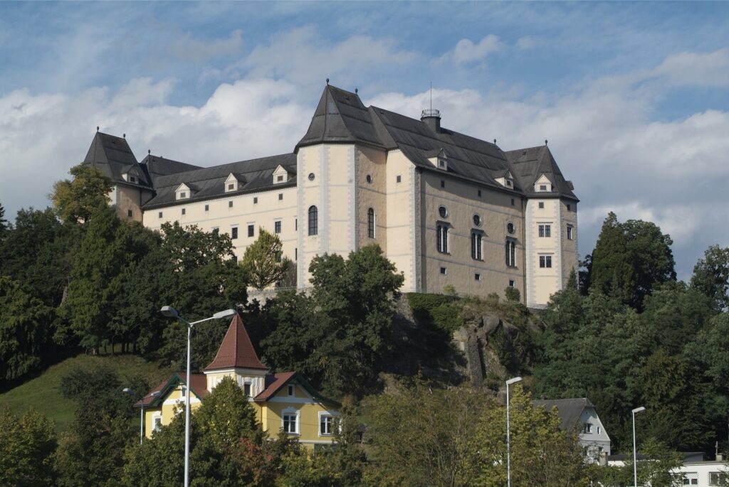 Historic Greinburg Castle surrounded by trees in Austria