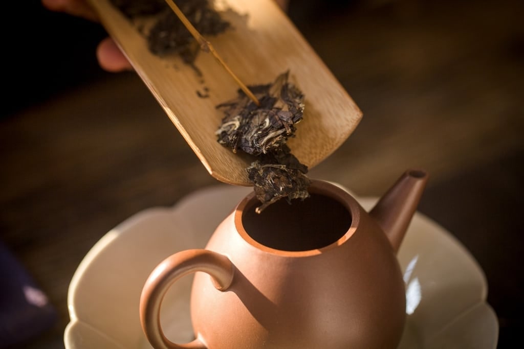 Chinese tea being poured into a teapot