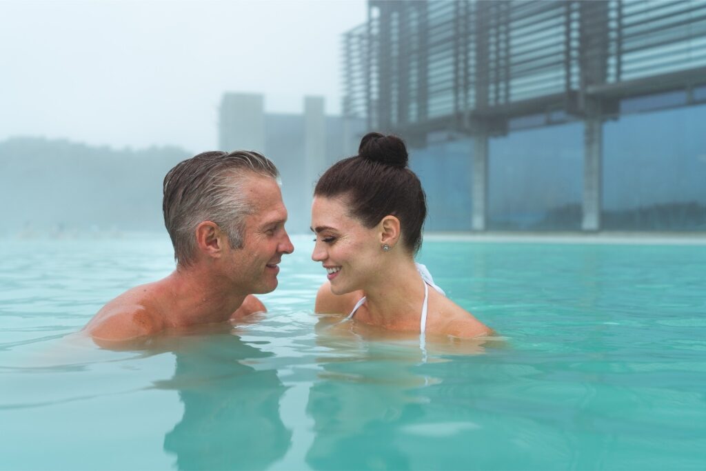 Couple relaxing in Blue Lagoon, one of the most popular geothermal lagoons in Iceland