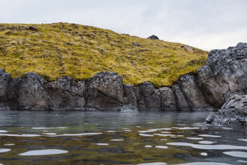 Sky Lagoon with rocky terrain around steaming geothermal waters in Iceland
