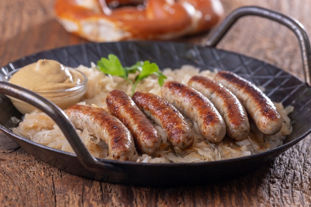 Plate of Nürnberger Rostbratwürst sausages served with sauerkraut and mustard