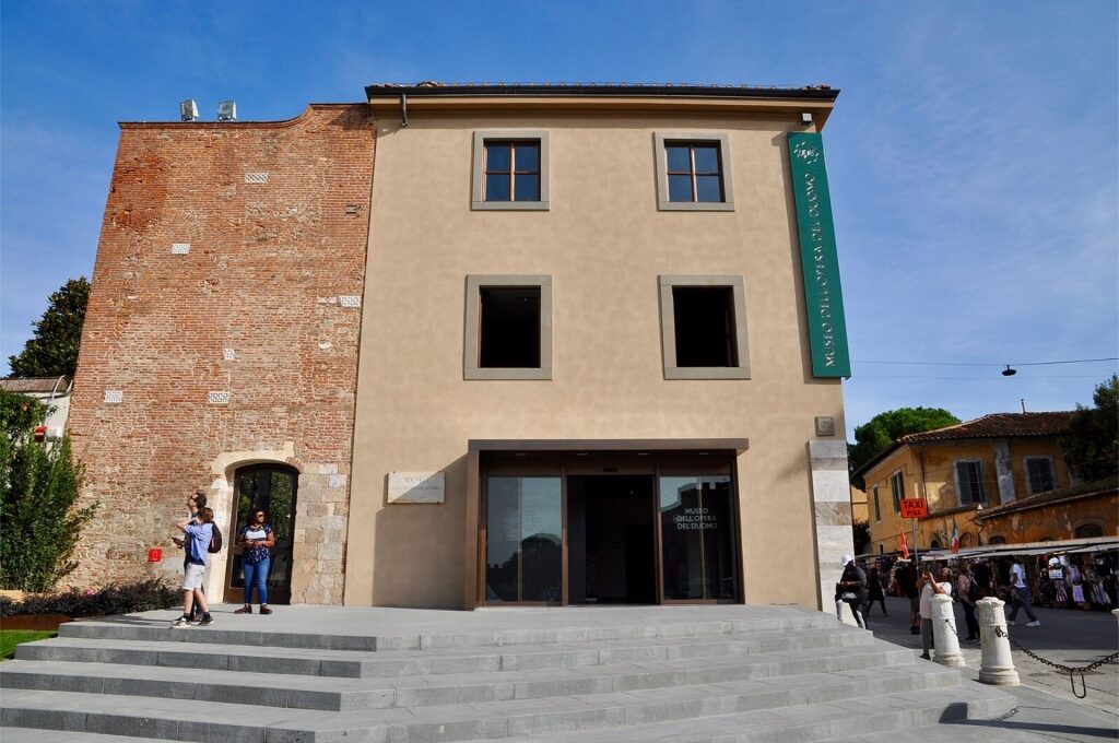 Museum building of Museo dell’Opera del Duomo with tourists outside in Pisa