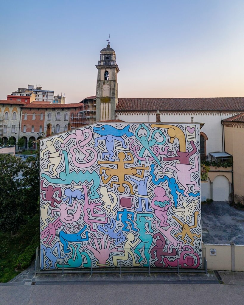 Colorful Tuttomondo mural by Keith Haring on a building wall in Pisa